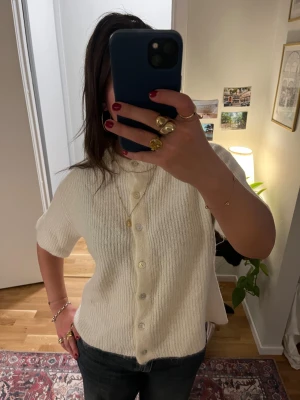 Vit stickad kofta från Gina Tricot - Kortärmad, ribbstickad kofta från Gina Tricot. 