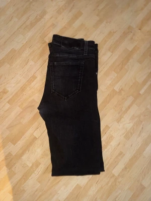 Svarta skinny jeans  - Svarta jeans med klassisk femficksdesign och smal passform. Jeansen har en låg midja och är tillverkade i stretchigt denim för en tajt look. Perfekta för dig som gillar en stilren och enkel vibe. Snygga att matcha med sneakers eller boots.