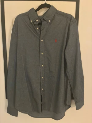 Blå oxfordskjorta från Ralph Lauren - Polo Ralph Lauren skjorta i storlek S Grå button-down med röd broderad logga. Bra skick.