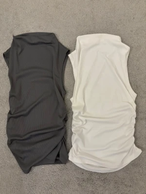 Sommartoppar - Två stilrena ribbade toppar i ärmlös modell, en i vit och en i mörkgrå. Fint att ha tillsammans med jeans eller någon kjol!  Materialet är också super skönt 