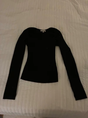 Svart ribbad långärmad tröja H&M - Säljer en svart, uringad långärmad tröja från H&M i storlek S.Tröjan har en slim passform och är stickad i mjukt material med rund hals.