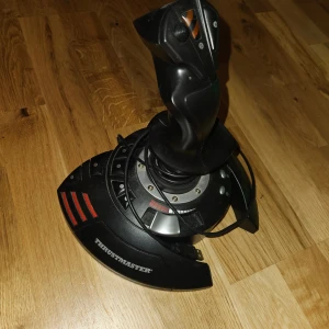 Thrustmaster T-Flight Stick X - Thrustmaster T-Flight Stick X är en robust och populär joystick för PC och PlayStation. Perfekt för flygsimulatorer med flera programmerbara knappar och ergonomisk design. Produkten visar lätt ytslitage men är i gott skick och redo för spel.