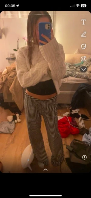 Randiga vida byxor med snörning - Säljer ett par svarta och vita randiga byxor med snörning i midjan. Byxorna har en loose och wide passform med raka ben och är riktigt sköna att ha på sig. Perfekta för dig som gillar avslappnad stil och vill ha något som sticker ut lite extra.