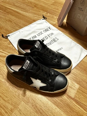 Golden Goose svartvita sneakers - Säljer riktigt snygga och lite använda Golden Goose-skor i modellen Superstar ❗✌️. Skorna är i storlek 42, men passar även en 41. Det som ingår: skor, box, tagg och kvitto. Skorna kostar runt 500 € nya. Priset är inte hugget i sten, så det går att förhandla, och om du har några frågor är det bara att skicka ett meddelande till mig. 🤗