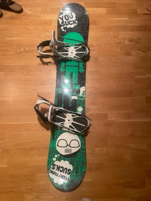 Snowboard med bindningar - Säljer en skit snygg snowboard och ett par snowboardbindningar i svart och vitt med cool grafisk design. Bindningarna har robust konstruktion och kan justeras på brädan. Brädan är bra kondition men har använts ca 10 gånger men funkar såklart helt normalt.