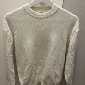 Vit stickad tröja från Zara - Säljer en stilren vit tröja från Zara i storlek 164cm (13-14 år). Tröjan har en klassisk rund hals och långa ärmar, perfekt för en minimalistisk look. Tillverkad i ett mjukt material som ger en bekväm känsla. Passar bra till både till finare tillfällen men även för en skön hemma outfit.