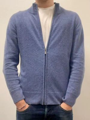 BLÅ KASHMIR FULLZIP - Säljer en stilren blå kofta från CASH-MERE i 100%. Passar perfekt för att hålla sig varm i det kalla vädret. Modellen är 177cm, väger 70kg och har storlek M. Tröjan säljs då den inte kommer till användning längre😁