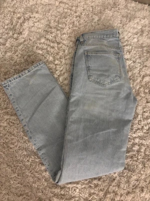 Ljusblå jeans från g perfect jeans - Säljer ett par ljusblå jeans från g perfect jeans i rak modell. Är i storlek 32 men är mer som 34. Jeansen har klassisk femficksdesign och är tillverkade i jeansmaterial med fransad kant längst ner på benen för en chill vibe. Perfekt för dig som gillar enkel och stilren denim.