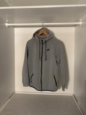 Grå Nike tech fleece full-zip hoodie  - Säljer en Nike tech fleece full-zip hoodie i grå färg. Fantastiskt kvalité, inga missfärgningar eller märken på ärmar eller luva.   Storlek: M Bröst: 52 cm  Längd: 70 cm  Leverans sker senast dagen efter:)