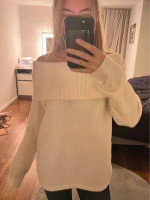 Offshoulder krämvit stickad tröja - Superfin krämvit stickad tröja med bred ribbad kant upptill som sitter offshoulder. Mjuk och skön, perfekt för lager på lager och chill dagar. Långärmad och loose fit för en avslappnad vibe.