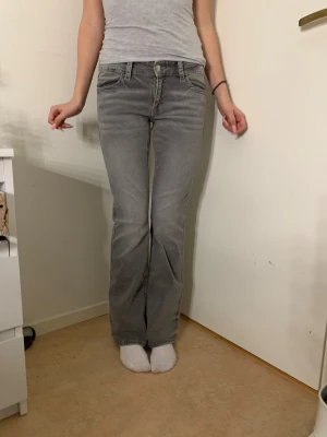 Grå bootcut jeans med detaljer🩷 - Säljer ett par gråa bootcut jeans med snygga fickdetaljer bak och klassisk femficksdesign. Jeansen har låg midja och är tillverkade i mjukt bomullsmaterial med lite stretch. Perfekt passform och stilren look som funkar till många outfits.🩶