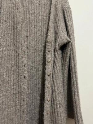 Beige lång kofta från NA-KD - Lång, ribbstickad beige kofta från NA-KD med v-ringning och knappar hela vägen framtill. Koftan har långa ärmar och är gjord i ett mjukt, stickat material som känns extra mysigt. Perfekt för lager-på-lager och chill dagar. Storlek M passar även för dig som har L