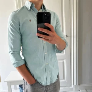 Ljusblå skjorta från Ralph Lauren  - Snygg ljusblå skjorta från Ralph Lauren i custom fit. Skjortan är i storlek M men sitter som S. Tveka inte för att ställa frågor!