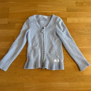 Ljusgrå kofta från Odd Molly - Superfin ljusgrå kofta från Odd Molly med snygg stickad struktur, dragkedja framtill och dekorativa detaljer vid fickorna. Köpt på plick men säljer vidare då den inte passade mig tyvärr! Mycket bra skick och helt oanvänd av mig. Storlek 0 vilket motsvarar XS. Tvättar innan jag skickar💞