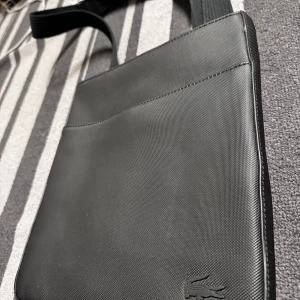Svart axelväska från Lacoste - Hel ny Lacoste axelväska, den äkta och kvitto finns. Aldrig använd