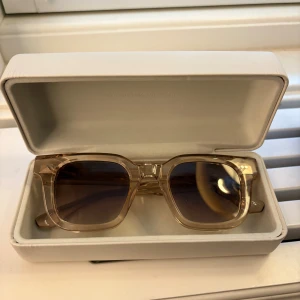 Solglasögon CHIMI 04 - Snygga solglasögon från CHIMI med transparent beige båge och fyrkantig form. Glasen är mörka och ger en cool kontrast till den ljusa ramen. Kommer med originaletui. Endast använda 2-3 gånger💞