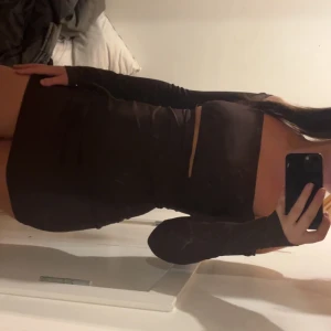 Brun tight offshoulder klänning - Säljer en brun, tight och kort offshoulder-klänning med långa ärmar. Klänningen har en kroppsnära passform och är perfekt för dig som vill ha en stilren och trendig look. Materialet känns mjukt och följsamt mot kroppen.