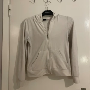 Vit hoodie från Gina Tricot XS - Vit hoodie från Gina Tricot i storlek XS. Tröjan har dragkedja framtill, huva med snörningshål och två stora fickor. Mjuk och skön, perfekt för chill dagar. Långärmad och i klassisk passform.