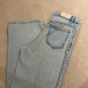 Ljusblå jeans från Lindex - Säljer ett par ljusblå jeans från Lindex med klassisk femficksdesign och dragkedja. Jeansen har raka ben och normal passform, tillverkade i mjukt bomullsjeans. Perfekta för en avslappnad och trendig look. Och är högmidjade 