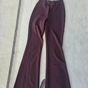 Mörklila bootcut byxor från H&M XS - Snygga mörklila bootcut byxor från H&M i storlek XS. Byxorna har en hög midja och är tillverkade i ett mjukt, stretchigt material som sitter skönt. Perfekta för dig som gillar en trendig siluett med utsvängda ben.