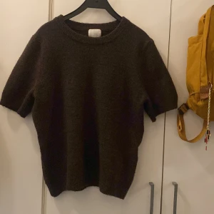 Brun stickad kortärmad tröja H&M - Mysig brun stickad tröja från H&M med korta ärmar och rund halsringning. Nyköpt och bara andvänd 2 gånger. 
