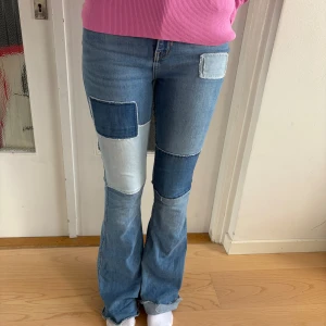 Patchade flare jeans från Hollister - Snygga ljusblå jeans från Hollister med patchwork-detaljer i olika blå nyanser. Modellen är high-rise flare med utsvängda ben och klassiska bakfickor. Jeansen är tillverkade i stretchigt denim för extra komfort och har coola kontrastsömmar.
