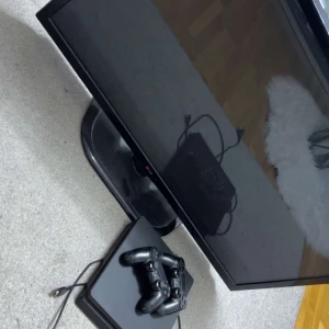 PlayStation 4 Slim och LG Tv - Sony PlayStation 4 Slim i gott skick, inklusive två original DualShock 4-handkontroller. Konsolen fungerar utmärkt och är perfekt för gaming. Mindre bruksspår kan förekomma, men inga synliga större defekter. Perfekt paket för spelkvällar! Dessutom en LG tv som funkar perfekt som skärm till konsolen