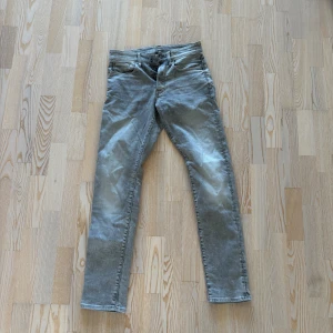 G-Star grå jeans slim fit - Säljer ett par grå jeans från G-Star, köpta för 1499kr och använt en gång! Slutsålda och går inte att hitta längre på hemsidan. Med en klassisk femficksdesign och smal passform. Jeansen har en snygg tvättad look och raka ben. Materialet är mjukt och stretchigt för extra komfort. Perfekta för dig som gillar stilrena och moderna jeans.