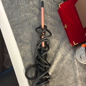 BaByliss Curling Wand - BaByliss locktång med sladd, perfekt för att skapa vackra lockar. Svart och roséguld design. Sladden är något trasslig men produkten ser ut att vara i gott skick utan synliga defekter. Enkel att använda och passar alla hårtyper.