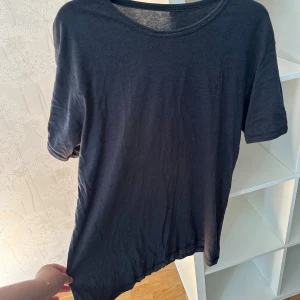 Mörkgrå t-shirt från Newbody XXL men är mer som M - En basic mörkgrå t-shirt från Newbody i storlek XXL. T-shirten har rund halsringning och korta ärmar. Tillverkad i mjuk bomullsblandning med 80% bomull och 20% polyester. Perfekt för en chill och avslappnad stil. Förekommer noppor.
