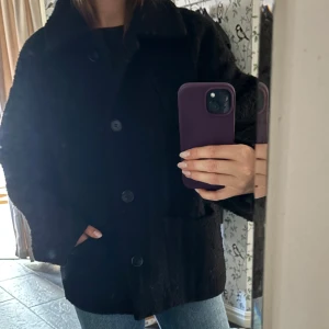 Svart ulljacka från Monki - Mycket bra skick! Svart jacka från Monki i ullmix med krage och stora knappar framtill. Jackan har en boxig, lite oversized passform och två fickor framtill.