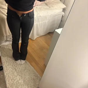 Svarta bootcut byxor från Nelly - Säljer ett par svarta bootcut byxor från Nelly. Köpte dessa byxor jättenyss och dem är som nya. Jag beställde en förliten storlek så kan inte knäppa dem. När jag testade dem lossnade lappen vilket gör att jag inte kan lämna tillbaka dem. Pris kan diskuteras ❣️❣️