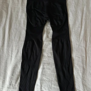 Svarta seamless leggings från Thrivin - Svarta seamless leggings från Thrivin med ribbade detaljer och scrunch-effekt bak. Hög midja och stretchigt material som sitter tajt. Väldigt tajta så skulle passa XS🖤