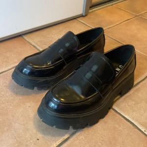 Svarta loafers  - Säljer ett par chunky svarta loafers från Unified med glansig finish och kraftig sula. 