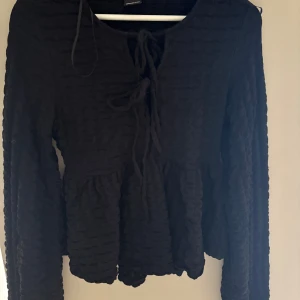 Svart blus från Gina Tricot  - Super fin blus från Gina som går att knyta framtill med en liten volang som går runt hela tröjan! 