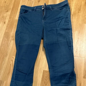 Blå jeans från Filippa K, storlek XL - Snygga blå jeans från Filippa K i modellen Patti Patch. Jeansen har klassisk femficksdesign, dragkedja och dubbla knappar i midjan. Materialet är mjukt denim och färgen är en djup blå med lätt tvättad look. 