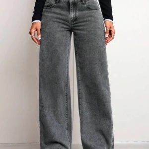 Gråa wide jeans med hög midja - Snygga grå jeans med hög midja och breda ben. Jeansen har klassisk femficksdesign och raka, vida ben som ger en cool och avslappnad look. Perfekta att styla med crop top eller hoodie för en trendig vibe.
