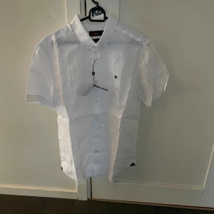 NY SKICK Morris kortärmad skjorta - Säljer en helt ny kortärmad vit skjorta från Morris i storlek M. Hör av dig vid funderingar!