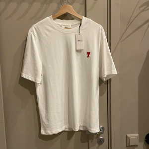 Vit t-shirt från Ami med rött hjärta - Vit t-shirt från Ami Paris. Storlek S. Prislapparna är kvar på. Äkta
