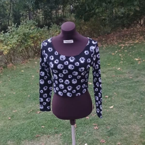 Blommig långärmad magtröja - Snygg croppad långärmad topp från H&M med svart botten och vita blommor över hela tyget. Toppen är tillverkad i mjuk bomull med lite stretch för en bekväm passform. Står storlek 38 men skulle mer säga 36. Det är bara att skriva om man har frågor!😊💖