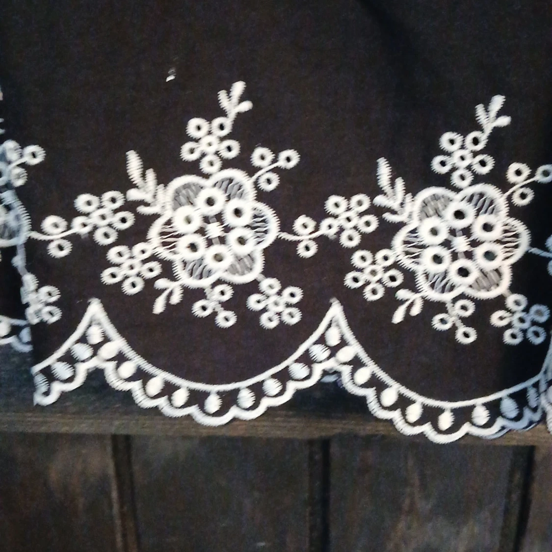 Svart linnetopp med broderade blommor