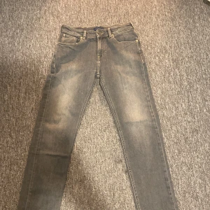 Grå jeans Scotch & Soda Dean - Säljer ett par grå jeans från Scotch & Soda, modell Dean. Jeansen har klassisk femficksdesign, raka ben och snygga kontrastsömmar. Materialet är mjukt denim och färgen är en tvättad grå nyans. Perfekta för en avslappnad och stilren look.