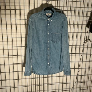 Tiger of Sweden - Skjorta, Jeans/Denim, - Tiger of Sweden, Style ”RIT”- Skjorta, Jeans/Denim, ljus denimtvätt,, button-down krage -Material: 100% bomull -Storlek: Small Mått- Längd: 79cm Axlar: 46cm Armpit to armpit: 46cm Midja: 44cm Ärm (nedre ärm): 50cm -Skick: Använd, mycket bra, utan anmärkningar