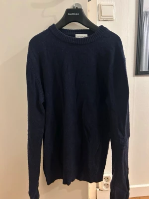 Mörkblå stickad tröja These Glory Days - Mysig mörkblå stickad tröja från These Glory Days. Klassisk rund halsringning och långa ärmar. Perfekt för lager på lager under kyliga dagar. Enkel och stilren design som funkar till det mesta.