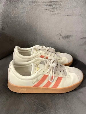 Adidas sneakers white/pink – EU 37.5 - Adidas sneakers i vitt med rosa detaljer. Använda men i fint skick. Storlek EU 37.5. Säljs pga rensning 💕passar storlek 37 och 38  