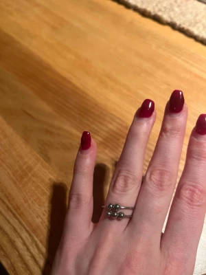 Snygg silverring med rörliga kulor - Unik och stilren silverring med två tunna band och små, rörliga, silverkulor. Ringen har en modern och minimalistisk design som passar perfekt för dig som gillar enkla men coola smycken. Perfekt att bära ensam eller att kombinera med andra ringar. Passar att ha på ringfingret för mig som har strl 17.