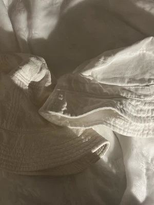 Vit bucket hat från Gina Tricot - Säljer två  vit bucket hat från Gina Tricot och weekday. Båda e gsk små i storlek. Andvänd nån gång men e i mycket bra skick