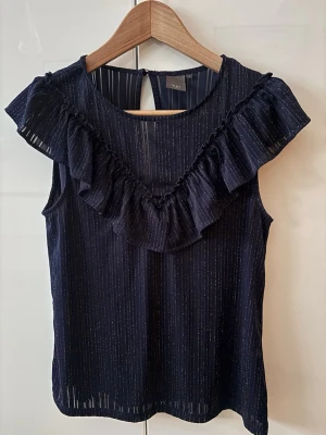 Mörkblå blus med volang från ICHI - Säljer en mörkblå glittrig topp i storlek S. Skit snygg till fest eller finmiddag!🍾🥳