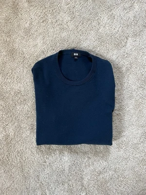 Stickad marinblå ulltröja från Uniqlo - Säljer en snygg och skön stickad 100% merinoull tröja från uniqlo | Väldigt fint skick | Nypris: 1200kr | Säljer nu för endast 499kr |  Storlek M | Skriv vid frågor! 