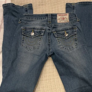 True Religion lågmidjade bootcut - Lågmidjade bootcut jeans från True Religion. Snygga detalje på bakfickorna. Storlek W24/xs. Jättebra skick, som nya! Nypris 1400:-💕PRIS KAN DISKUTERAS! LÄGG PRISFÖRSLAG! 